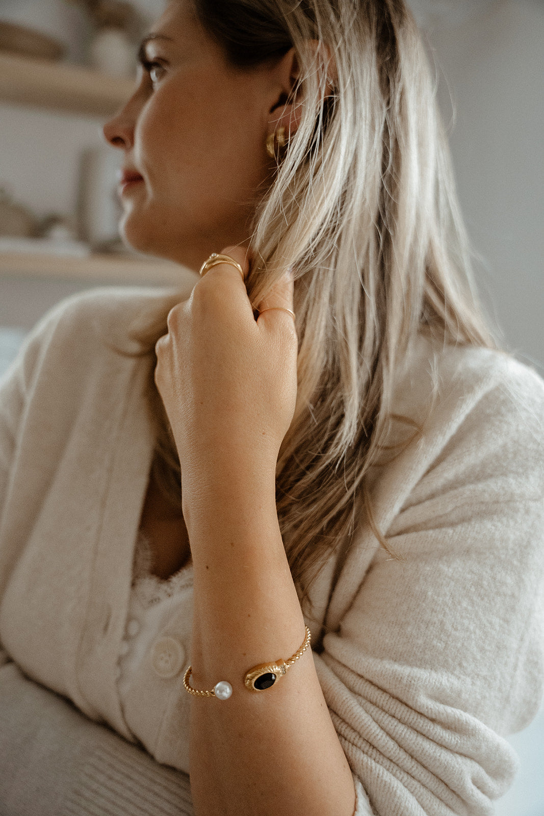 Bracelet torsadé rigide ouvert ajustable inox or avec onyx noir et parle porté sur une femme - lifestyle