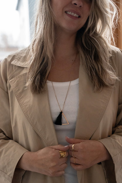 Collier long délicat placage or avec pendentifs triangle et pompon noir - Mariana 3-lifestyle sur une femme-2
