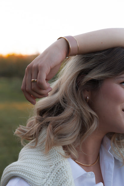 Bracelet rigide or avec cuir de pomme rose porté sur une femme à Québec - Kara x Sanana