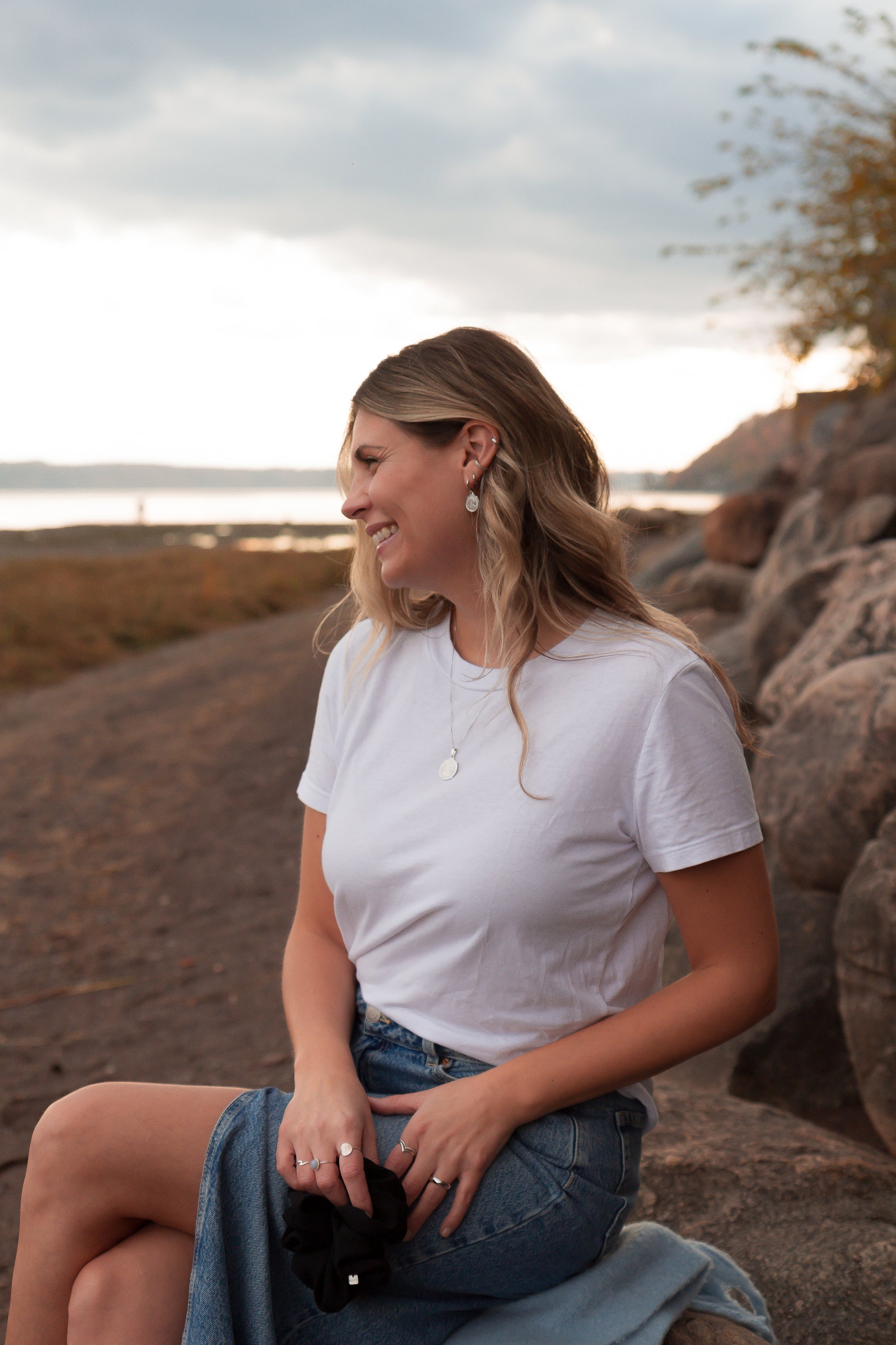 Bijoux délicats en argent sterling - collier, bagues et boucles d'oreilles - portés sur une femme